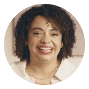 Smiling woman with curly hair wearing a white top, set against a circular coral background. Represents positivity, confidence, and Noom’s diverse and supportive user community.